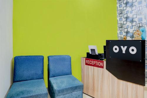two chairs in an office with a reception counter at Hotel O Aradhyaa Inn in Dispur