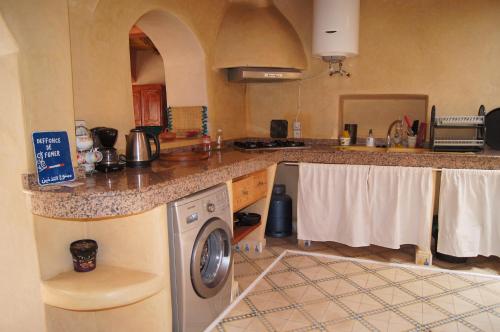 a kitchen with a washing machine and a counter at Villa Nouran - Chambre Hôte in Ghazoua