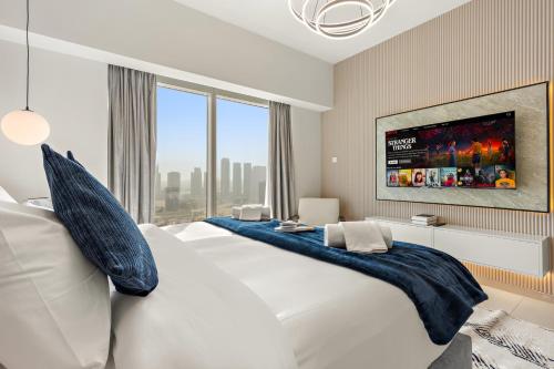 a bedroom with a large bed with a tv on the wall at Desert Key - Platinum Apartments in Gate Tower, Al Reem Island in Abu Dhabi