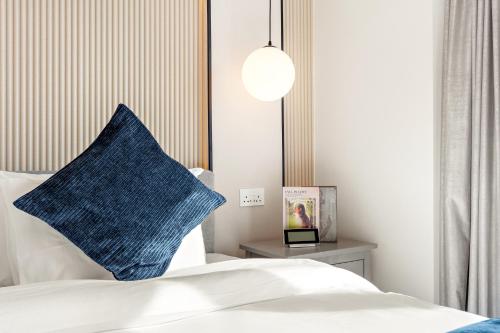 a bedroom with a blue pillow on a bed at Desert Key - Platinum Apartments in Gate Tower, Al Reem Island in Abu Dhabi