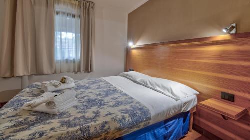 a bedroom with a large bed with a wooden headboard at Tenuta dell'Argento Pool&Relax by Rentbeat in Civitavecchia