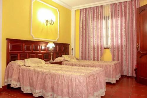 two beds in a room with yellow walls at Charming House with Pool in Buenavista del Norte in Buenavista del Norte