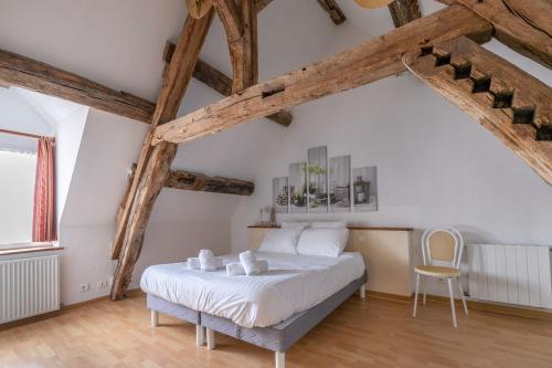 a bedroom with a bed in a room with wooden beams at 1 2 3 Sologne - La Nigaudière in Lassay-sur-Croisne