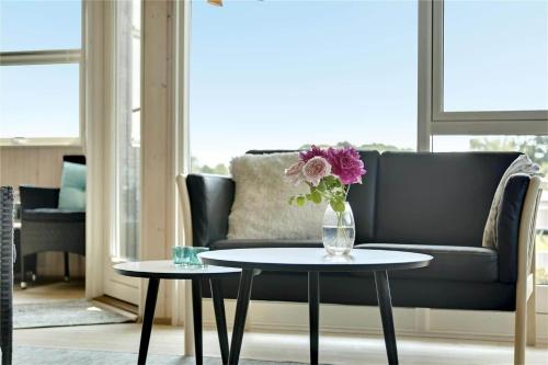a living room with a couch and a vase with flowers on a table at 30727-Odder-Alrovej-203-A in Odder