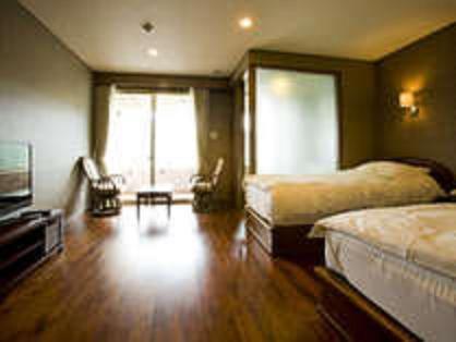 a bedroom with two beds and a wooden floor at Hotel Luandon Shirahama in Shirahama