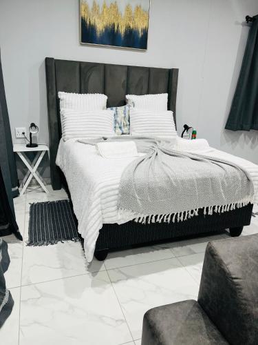 a bedroom with a large bed with white pillows at Audreys Haven Self catering accommodation in Rundu