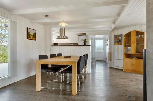 a dining room with a wooden table and black chairs at 30463-Odder-Solbakken-14 in Odder
