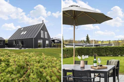 a black house with a table and an umbrella at 30467-Odder-Ravnsager-15 in Odder