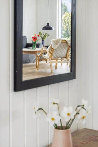 a mirror on a wall with a chair and a table at 30467-Odder-Ravnsager-15 in Odder