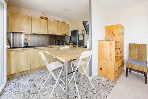 a kitchen with a wooden table and chairs at An Ti Gwerned - Proche Aéroport Rennes in Saint-Jacques-de-la-Lande