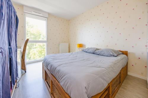 a bedroom with a bed and a large window at An Ti Gwerned - Proche Aéroport Rennes in Saint-Jacques-de-la-Lande