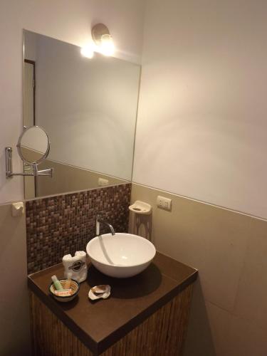 a bathroom with a sink and a mirror at Bamboo Lodge Paracas in Paracas