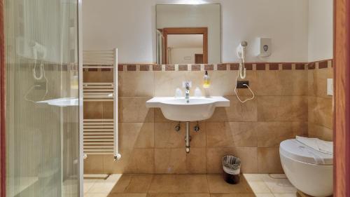 a bathroom with a sink and a toilet and a shower at Tenuta dell'Argento Pool&Relax by Rentbeat in Civitavecchia