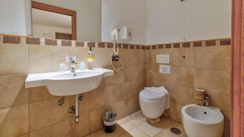 a bathroom with a sink and a toilet at Tenuta dell'Argento Pool&Relax by Rentbeat in Civitavecchia