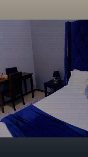 a bedroom with a bed and a desk and a table at Tubungu- House of Lux& Lush in Matsapha