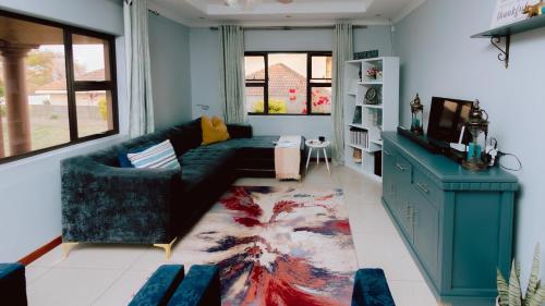 a living room with a couch and a tv at Tubungu- House of Lux& Lush in Matsapha