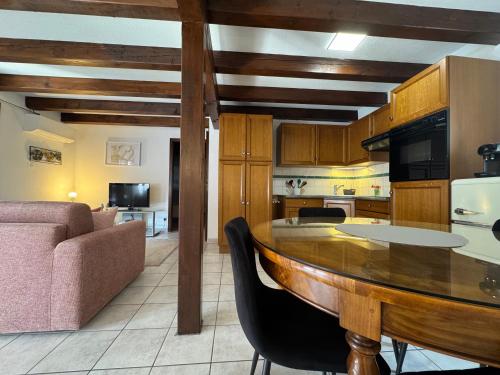 a kitchen and living room with a table and a couch at Relais du Dompeter in Molsheim