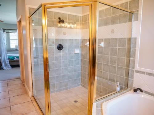 a shower with a glass door in a bathroom at New! Fair Winds Private Island Oases w Heated Pool & more! in Merritt Island
