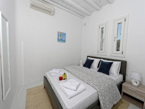 a white bedroom with a bed with a bowl of fruit on it at Villa in Mykonos with Sea View and Pool in Kalafatis