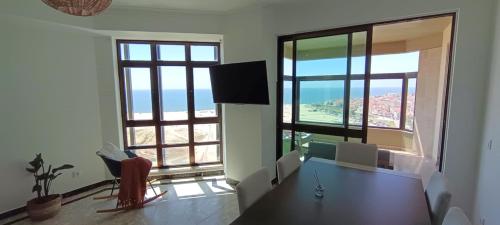 a dining room with a table and a large window at Buarcos&Sea Accommodation - Cristal Mar - Your Panoramic Ocean View Retreat in Figueira da Foz