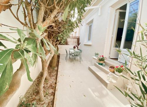 cortile con tavolo, sedie e albero di Maison 2 chambres à la plage avec jardin a Canet-en-Roussillon