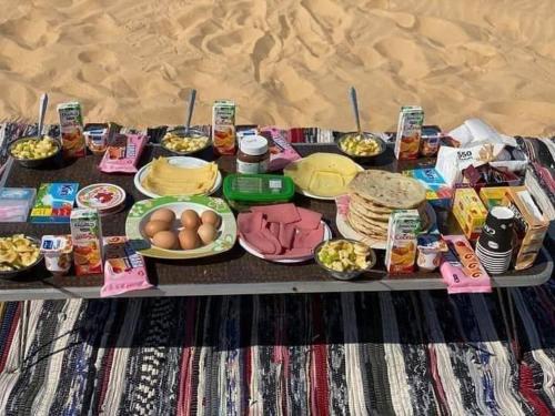 a table with food and eggs on a blanket at White desert camp in Bawiti