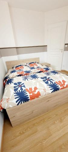 a bedroom with a bed with a colorful comforter at Un calme à la ville in Darnétal