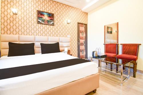 a bedroom with a bed and a desk and a chair at Hotel O THE WEDDING RINGS in Dhanbād