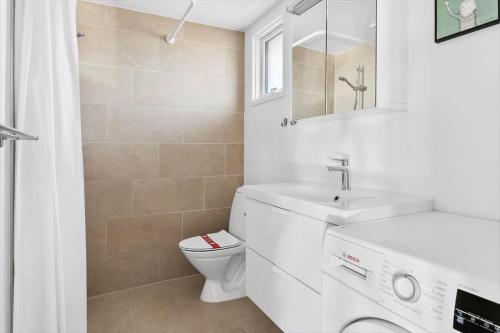 a white bathroom with a sink and a toilet at 30599-Odder-Strandagervej-1 in Odder