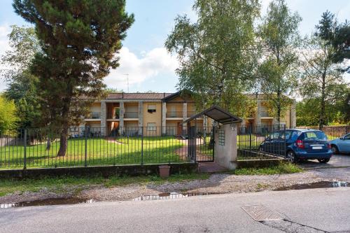 a building with a gate and a car parked in front at Residence Brughiera Malpensa in Lonate Pozzolo