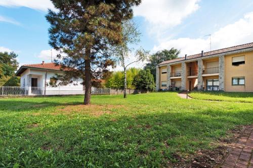 a building with a tree and a grass yard at Residence Brughiera Malpensa in Lonate Pozzolo