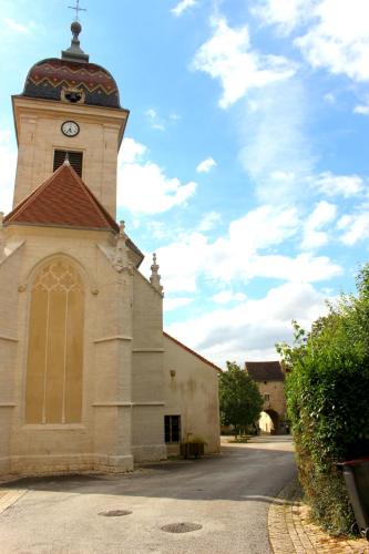 a church with a tower with a clock on it at Appartement Hibou in Pesmes