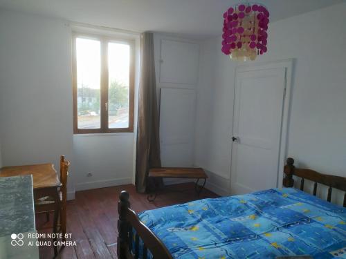 a bedroom with a bed and a table and a window at Appartement Hibou in Pesmes
