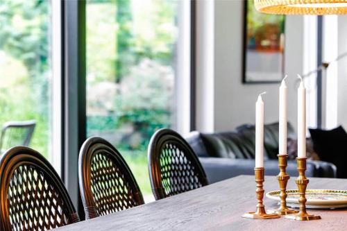 a table with three candles on a table with chairs at 30159-Odder-Thorasvej-24 in Beder
