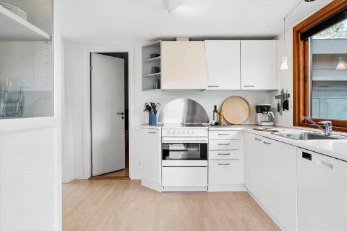 a white kitchen with white cabinets and a sink at 40157-Juelsminde-ElmeAlle-22 in Juelsminde