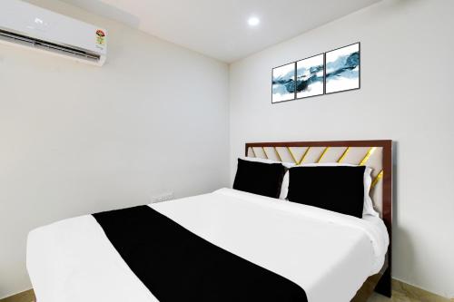 a white bedroom with a black and white bed at Hotel O Skyline in Surūrnagar
