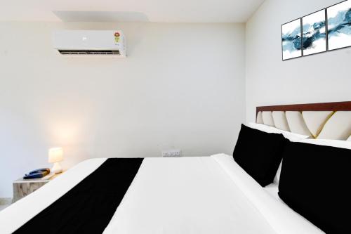 a white bedroom with a black and white bed at Hotel O Skyline in Surūrnagar