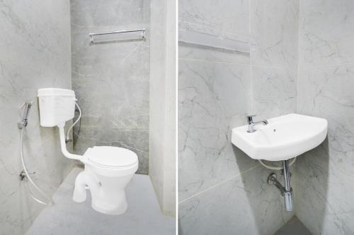 a white bathroom with a toilet and a sink at Hotel O Skyline in Surūrnagar