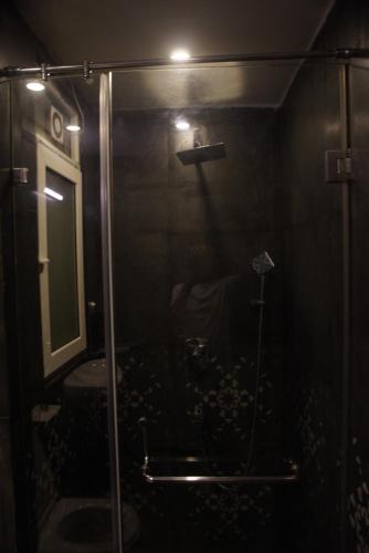 a bathroom with a shower with a mirror and a sink at Baga Courtyard in Anjuna