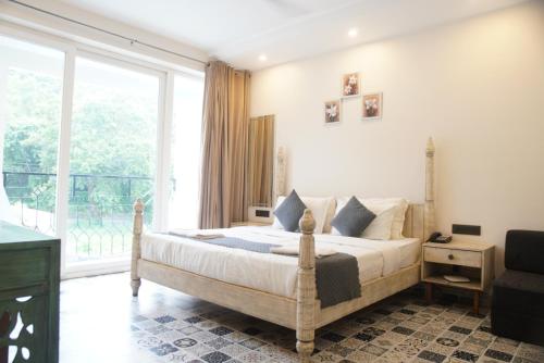a bedroom with a bed and a large window at Baga Courtyard in Anjuna