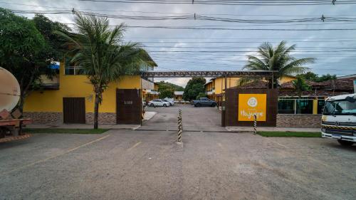a street with a yellow building and palm trees at Pousada Itajuípe- Unidade Itabuna-Ba in Itabuna