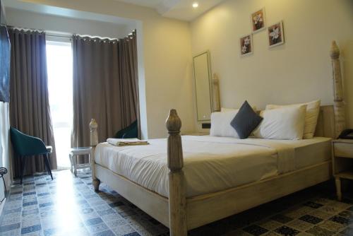 a bedroom with a large bed and a large window at Baga Courtyard in Anjuna