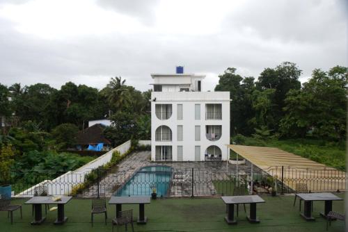 a white building with a pool in front of it at Baga Courtyard in Anjuna