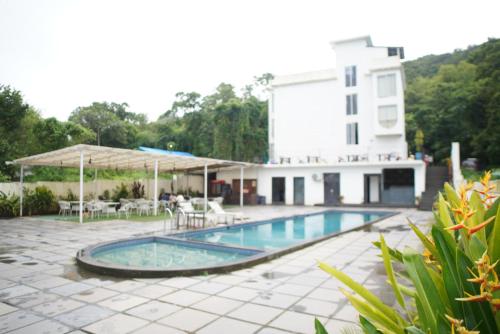 a swimming pool in front of a building at Baga Courtyard in Anjuna