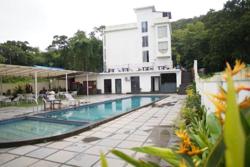a swimming pool in front of a building at Baga Courtyard in Anjuna
