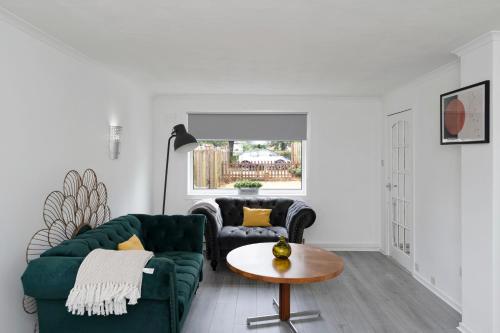 a living room with two green couches and a table at 3BR Family House with Free Parking in West Lothian in Whitburn