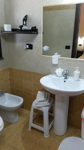 a bathroom with a sink and a toilet and a mirror at Agriturismo Il Pozzo Antico in Mascali