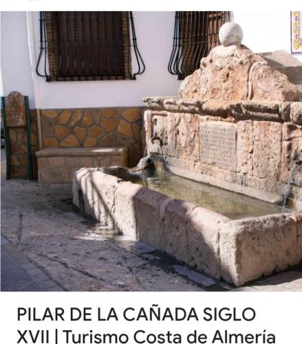 a fountain in a building with the words plar de la canada sigula at Casa Rural Pilar Seco in Laujar de Andarax