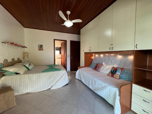 Pousada com café da manhã, piscina, natureza, sossego no Norte da Ilha, Ingleses في فلوريانوبوليس: غرفة نوم بها سريرين ومروحة سقف