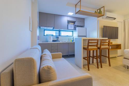 a living room and kitchen with a couch and a table at Allure Residence by Carpediem in Recife